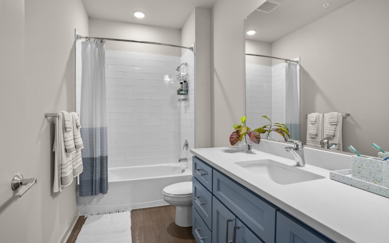 a spacious bathroom with a large mirror and ample light