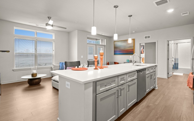 a kitchen with large island looking into the living space